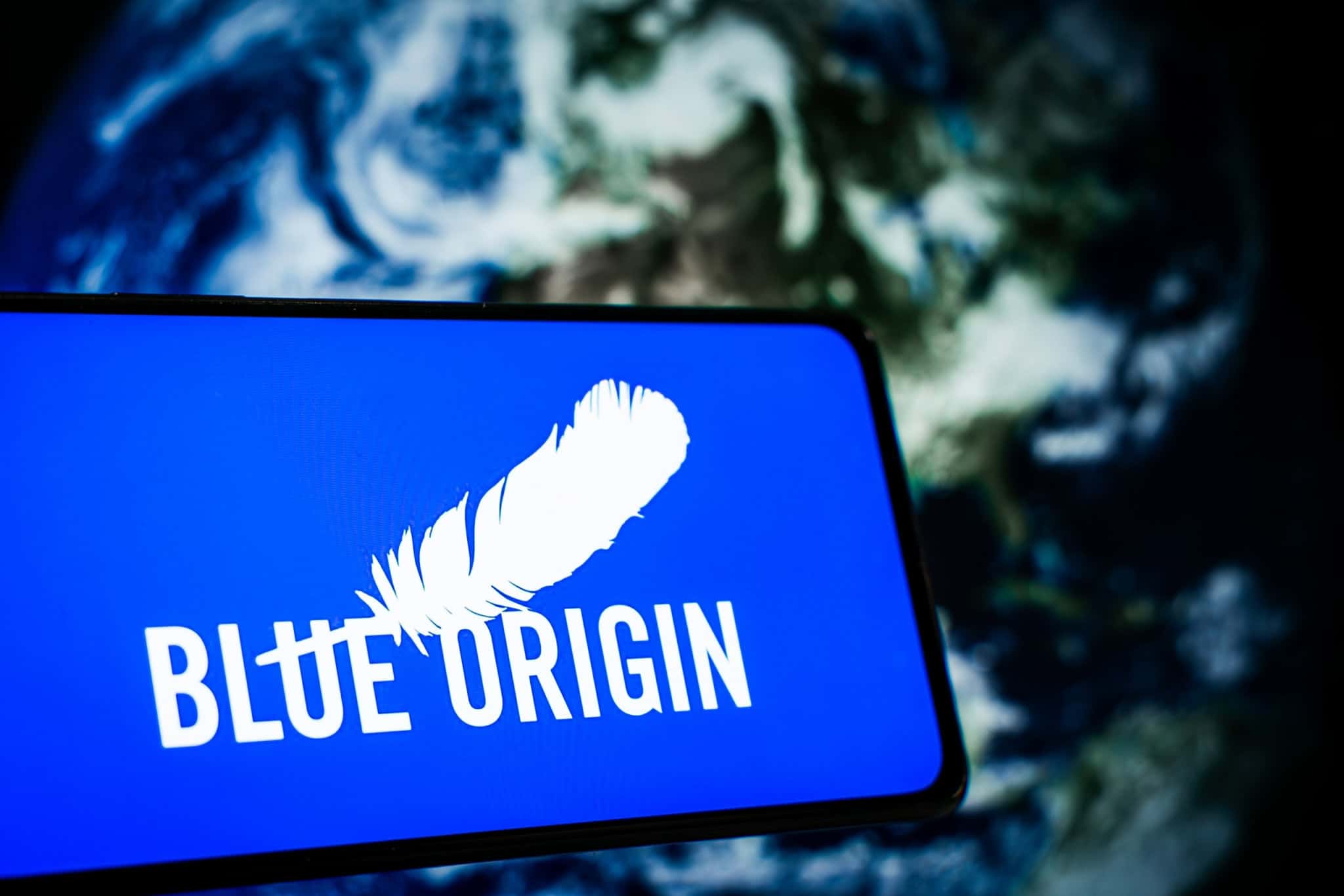 Ao fundo, imagem da Terra vista do espaço; à frente, logo da Blue Origin em um smartphone