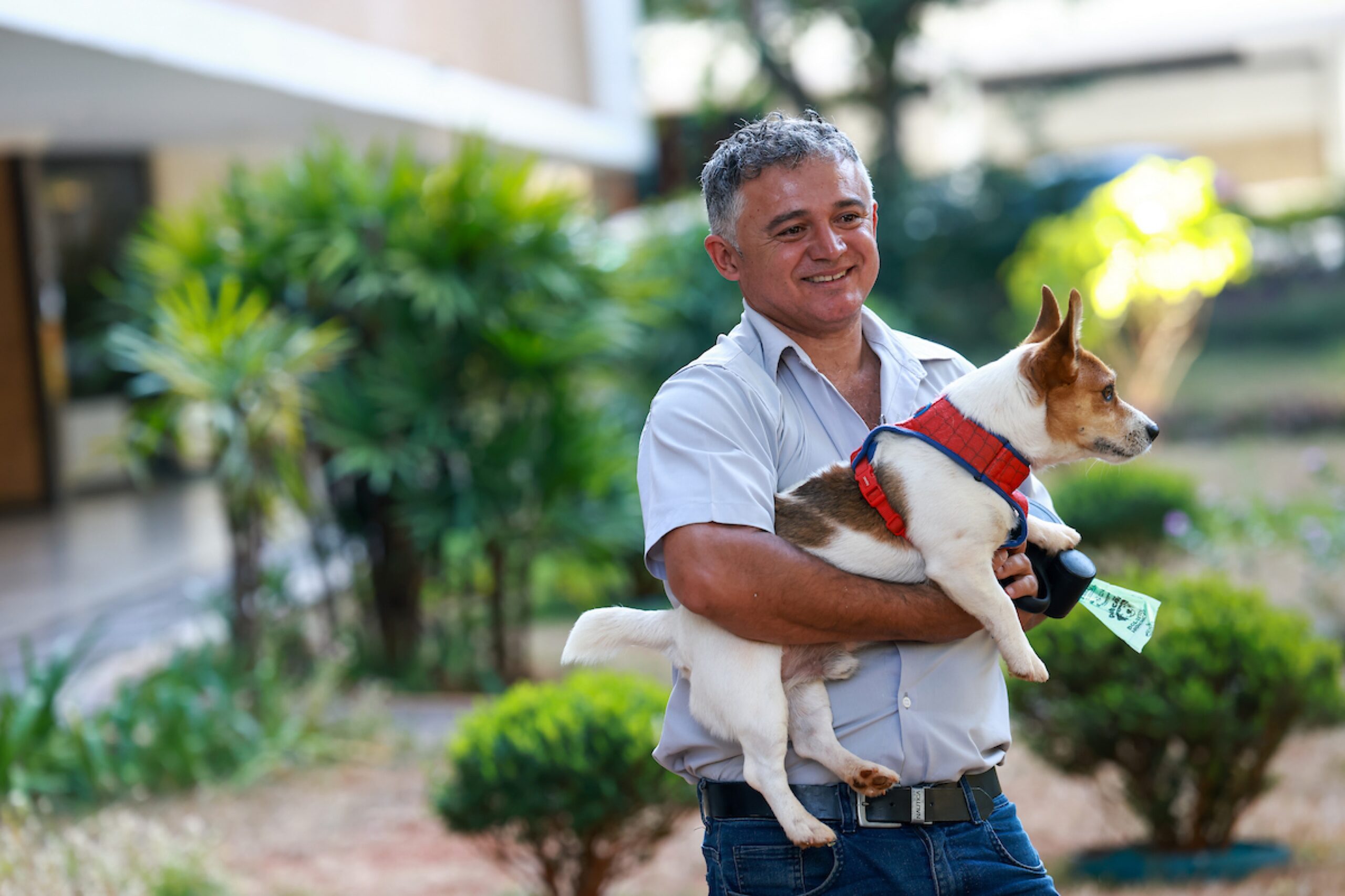 Imagem mostra homem segurando um cachorro - Metrópoles