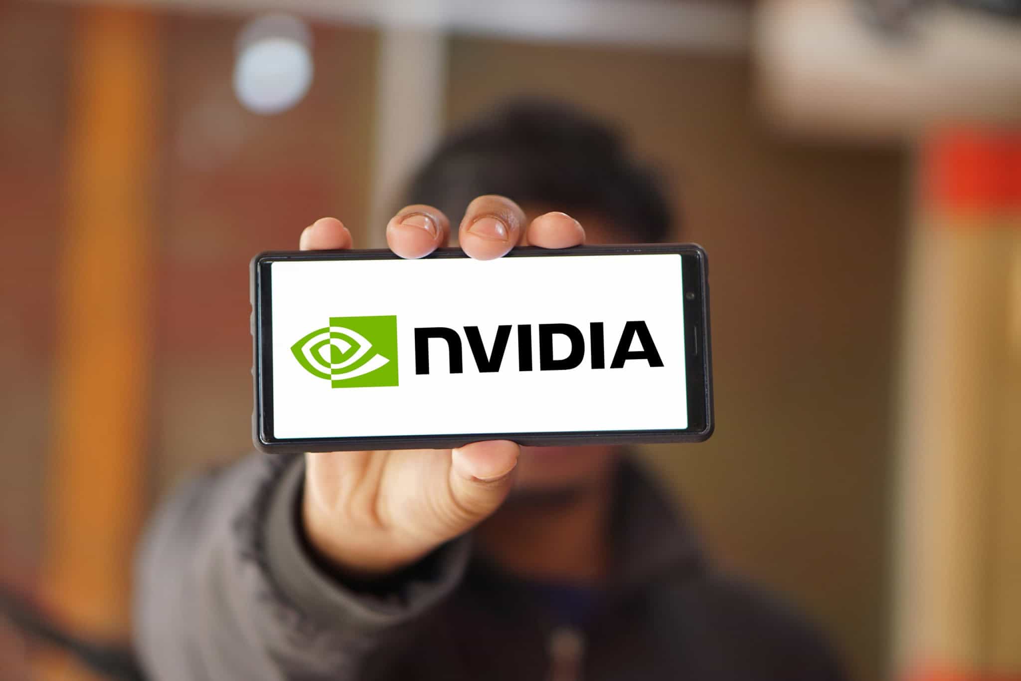 Pessoa segurando, na altura da cabeça, um smartphone na horizontal, no qual é visto o logo da Nvidia