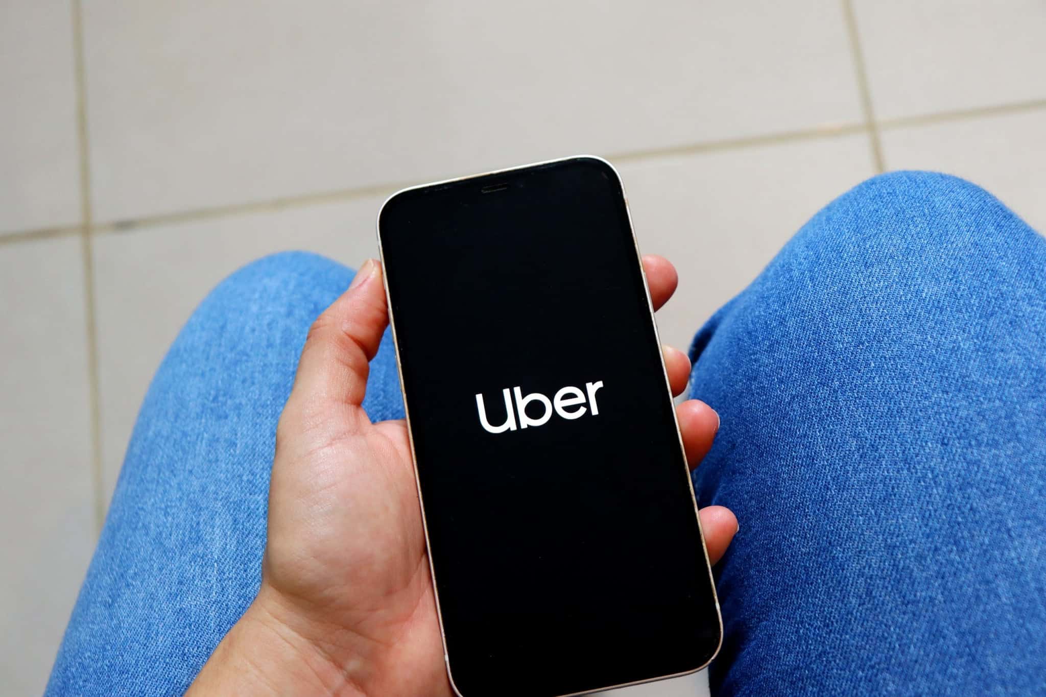 Logo da Uber em um smartphone na mão